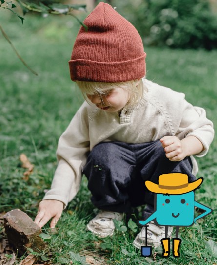 Image is of a young child squatting down and touching the grass and dirt with their fingers.  In the lower left hand corner of the picture is a cartoon blue square with a cute face wearing a gardening hat and boots and holding a shovel.